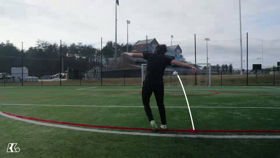 Player finishing a strike while the ball's flight path is traced toward goal.