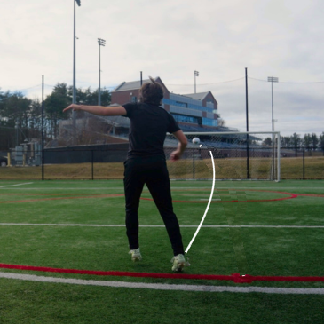 Player following through on a strike, with the ball's curving flight traced toward goal.